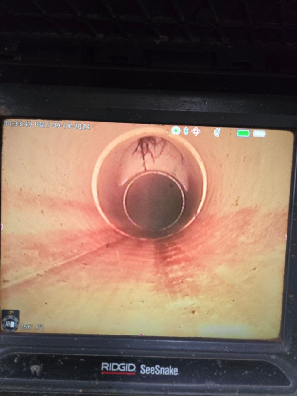 Camera view inside a sewer pipe showing a clear, cylindrical tunnel.